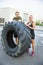 Confident Athletes Standing By Huge Tire Outside Health Club