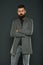 Confident and attractive. Confident hipster on grey background. Bearded man keeping arms crossed. Confident look of