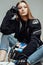 Confident and attractive female biker poses sitting on floor
