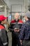 Confident bald mature foreman with tablet having discussion with subordinates