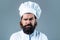 Confident bearded male chef in white uniform. Serious cook in white uniform, chef hat. Portrait of a serious chef cook