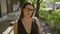 Confident beautiful hispanic woman, sporting glasses and a serious expression, making her stand on kyoto\\\'s traditional streets