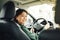 Confident and beautiful. Rear view of attractive young woman in casual wear looking over her shoulder while driving a car