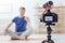 Confident blogger recording his new yoga lesson while being at home
