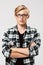 Confident blond handsome young man in glasses wearing casual plaid shirt with hands crossed on chest looking at camera