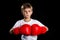 A confident boxer portrait with red boxing gloves together. The defend position portrait on the black background