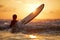 Confident boy carrying surfboard while standing at seaside in sunset