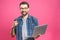 Confident business expert. Confident young handsome man with coffee in shirt holding laptop and smiling while standing against