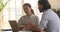 Confident businessman showing computer presentation to female client.