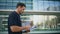 Confident businessman studying documents at street close up. Man holding papers