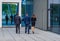 Confident businesspersons talking in front of modern office building. Businessmen and businesswoman have business