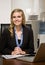 Confident businesswoman reading report at desk