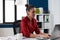 Confident businesswoman in red shirt working at desk in startup office.