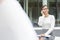 Confident businesswoman talking on smartphone while sitting against office building