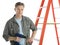 Confident Carpenter Holding Drill While Standing By Ladder