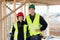 Confident Carpenters Wearing Reflective Jackets At Site