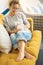 Confident caucasian adult woman sitting on the sofa reading a book using electronic device tablet reader. Pretty female people