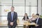 Confident caucasian manager in office seating on table