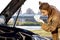 Confident caucasian woman driver checking oil level in car engine dipstick