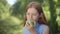 Confident charming redhead teenage girl biting chewing healthful apple smiling looking at camera. Portrait of happy