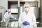 Confident cheesemaker in mask standing in cheese shaping workshop