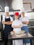 Confident Chefs With Sweet Dishes On Kitchen