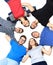 Confident college students forming huddle over white background