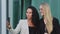 Confident diverse businesswomen chatting with colleague using smartphone outdoors, smiling multiracial millennial female