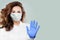 Confident doctor or nurse wearing a medical face mask showing stop pandemic gesture. Woman in safety mask and medical gloves.