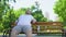 Confident fat man sitting in park, feels happy, contented with life, self-love