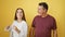 Confident father and daughter joyfully dancing together, radiating happiness and love on an isolated yellow background