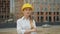 Confident female architect in a hard hat looks at the camera with his arms crossed over his chest. 4K