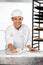 Confident Female Baker Cleaning Flour From Table