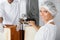 Confident Female Baker Using Cutting Machine In Bakery