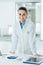 Confident female doctor leaning on desk