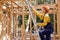 Confident Female on ladder,goes up to the roof, in wooden house site