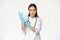 Confident female nurse, physician put on rubber medical gloves for patient clinical examination, standing serious in