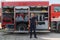 A confident firefighter strikes a pose in front of a modern firetruck, exuding pride, strength, and preparedness for