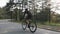 Confident focused cyclist pedaling on bicycle in the park. Road cycling training. Cycling concept. Slow motion