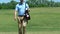 Confident golf player walking along fairway with golf bag, finishing his game