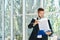 Confident handsome businessman with clipboard working on documents in a bright modern office with copy space