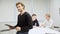 Confident handsome entrepreneur sitting on conference room table, turning to camera and looking in documents. Successful