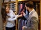 Confident handsome man with beard choosing a tie in a suit shop.