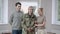 Confident handsome middle aged man in military uniform posing at home with wife and adult son. Positive Caucasian army