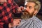 Confident in his perfect style. brutal bearded man at hairdresser. professional barber with male client. hipster with