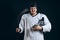 Confident hockey player looking at camera with skate in hand. Isolated on black.