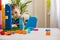 Confident male baby constructing tower with multicolored plastic pieces assembling house on table