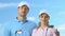 Confident male and female golfers posing with clubs, trainers of golf school