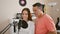 Confident male and female musicians singing a melodious song, sharing a high five in music studio, immersed in acoustic joy