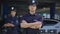 Confident male and female police officers in uniform standing near patrol car